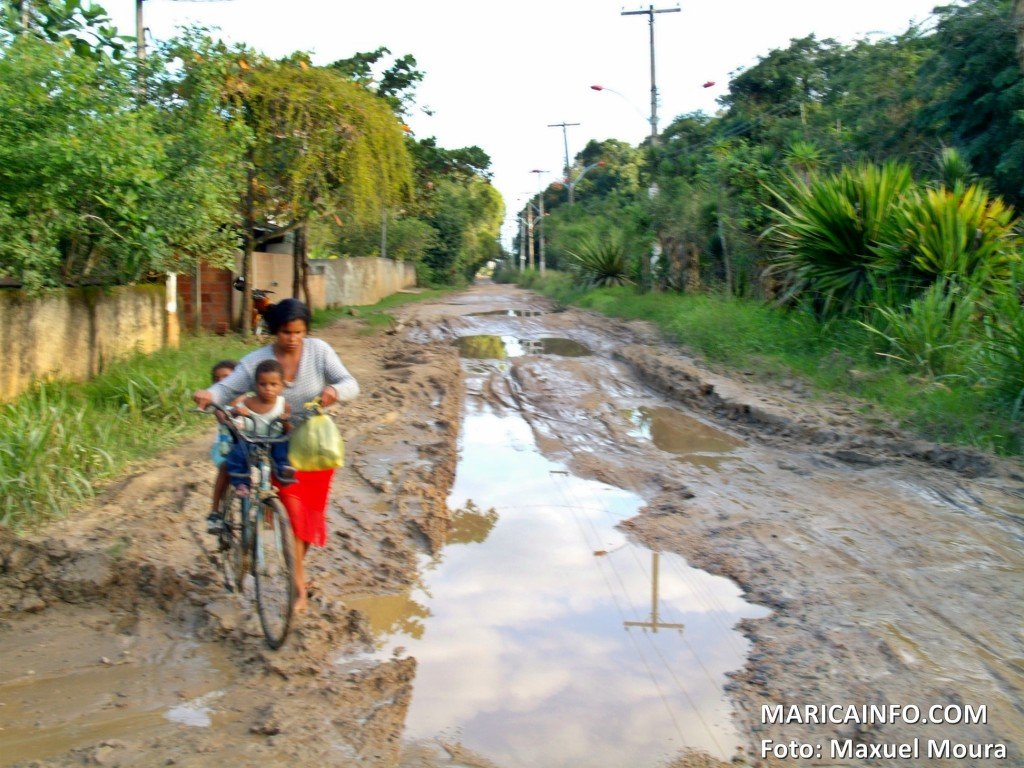 Moradores de Itaipuaçu sofrem sem infraestrutura urbana 7 Mulher atravessa com crianças em meio à lama. (Foto: Maxuel Moura | Maricá Info)