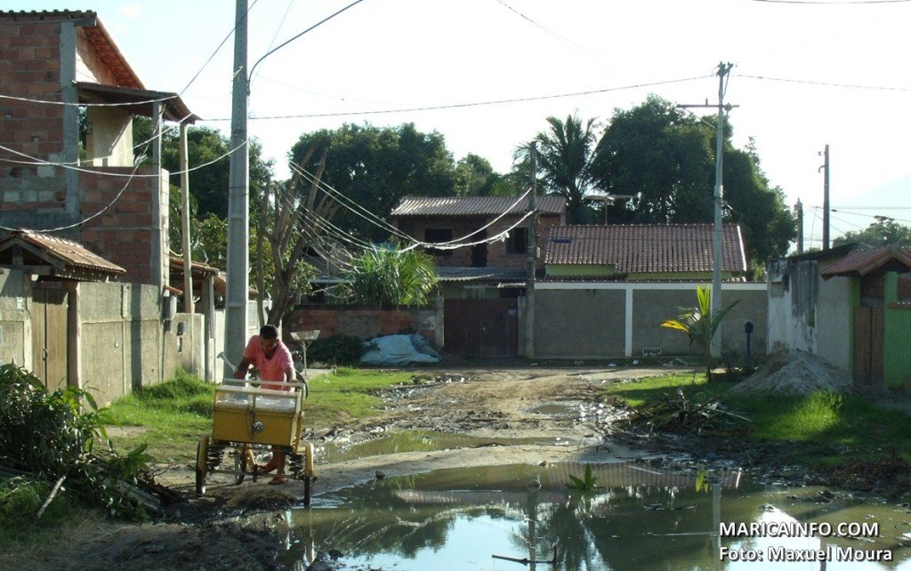 Mumbuca: Moradores sofrem com ruas intransitáveis 9 Vendedor tenta passar em rua cheia de lama na Mumbuca. (Foto: Maxuel Moura | Maricá Info)